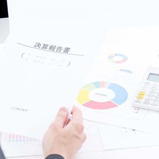 決算報告書を持つスタッフ